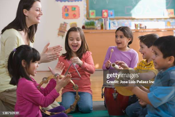 students playing musical instruments in classroom - elementary age - fotografias e filmes do acervo