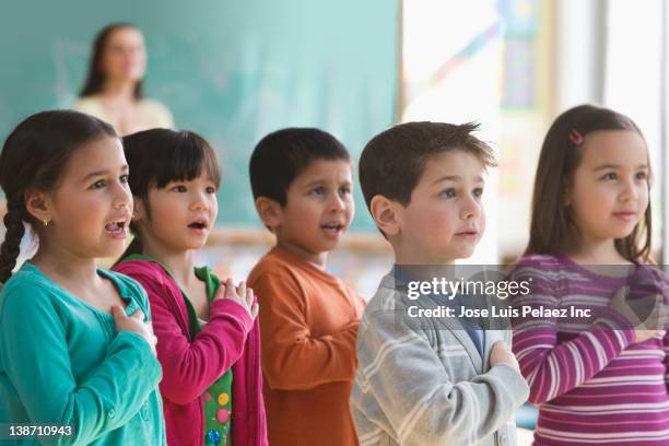 students saying the pledge of allegiance in classroom - amerikanischer treueschwur stock-fotos und bilder