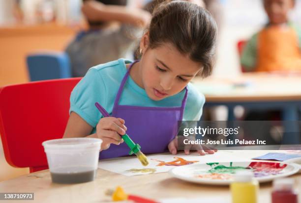 hispanic student painting in art class - art class stock pictures, royalty-free photos & images