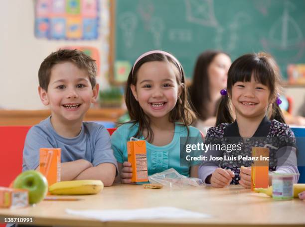 students eating lunch together in classroom - juice box stock pictures, royalty-free photos & images