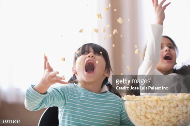 playful girls throwing popcorn - food copy space stock pictures, royalty-free photos & images