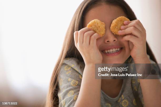 hispanic girl covering eyes with chicken nuggets - chicken nuggets stock-fotos und bilder