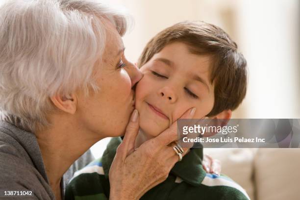 caucasian grandmother kissing grandson - cheek kiss stock pictures, royalty-free photos & images