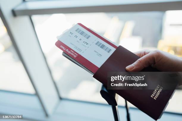 bereit für die reise: ein unkenntlicher kaukasier mit seinem pass und anderen dokumenten - bordkarte stock-fotos und bilder