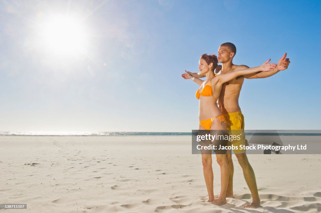 Mixed race couple standing together on beach