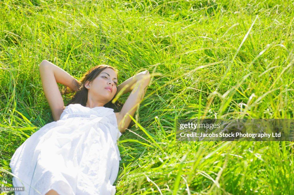 Hispanic woman sleeping in grass