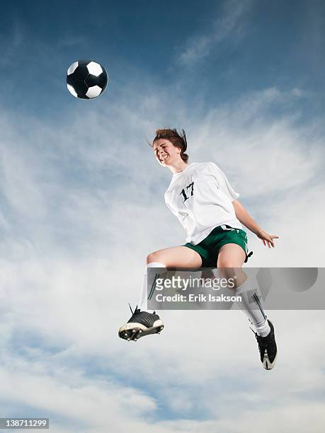 caucasian teenager heading soccer ball in mid-air - mit dem kopf stoßen stock-fotos und bilder