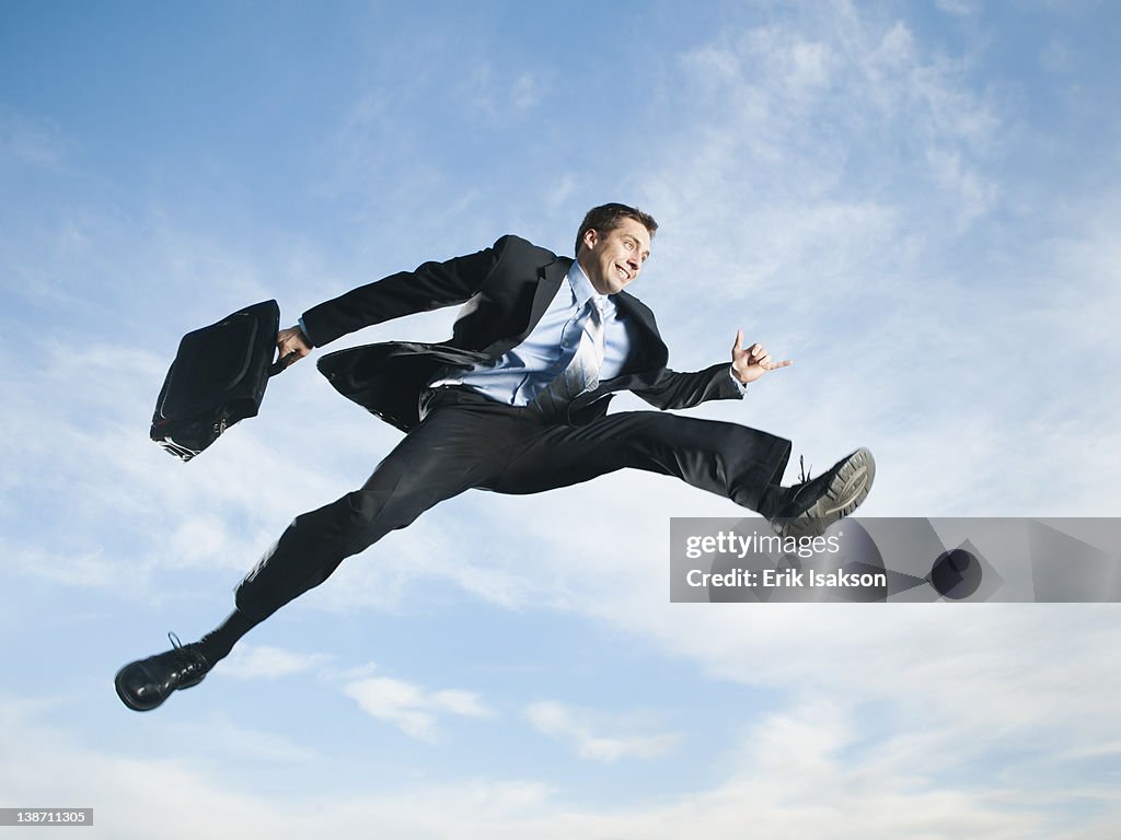 Caucasian businessman jumping in air