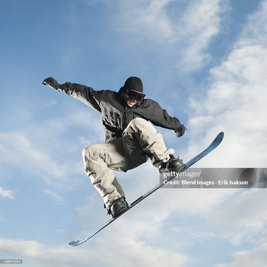 Caucasian man on snowboard in mid-air