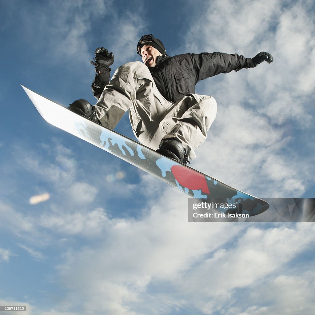 Caucasian man on snowboard in mid-air