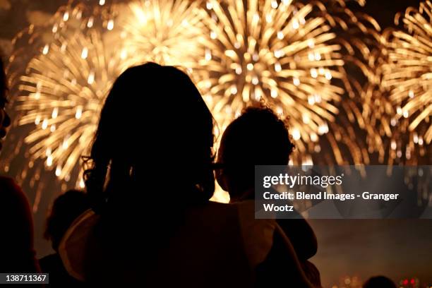 silhouette of mother and daughter watching fireworks - firework display imagens e fotografias de stock