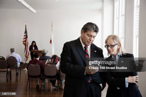 hispanic businessman text messaging on cell phone - plaatselijk overheidsgebouw stockfoto's en -beelden