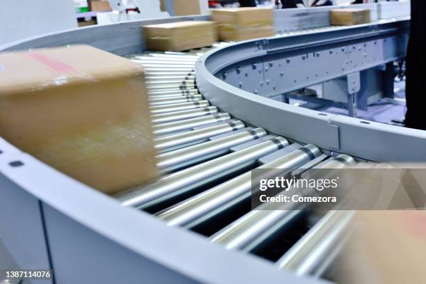 corrugated cardboard boxes moving on conveyor belt - assembly belt stock pictures, royalty-free photos & images