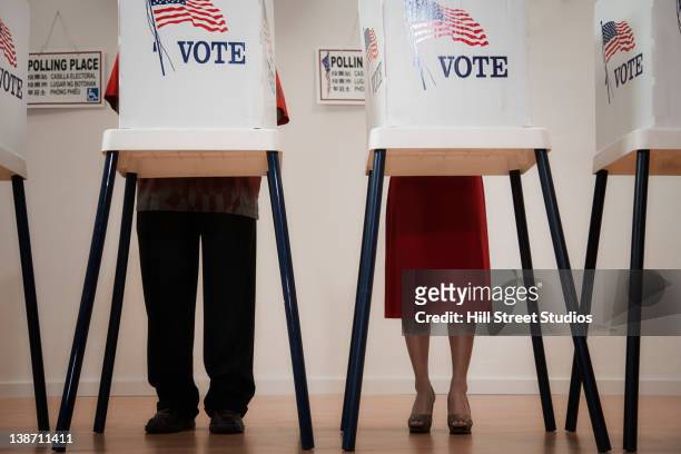 voters voting in polling place - stimmabgabe stock-fotos und bilder