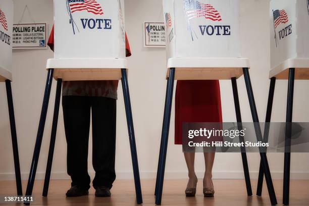 voters voting in polling place - votar fotografías e imágenes de stock