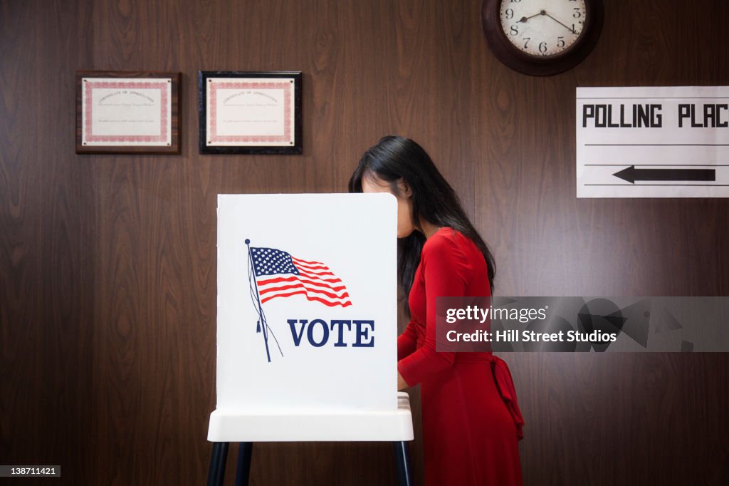 Asian voter voting in polling place