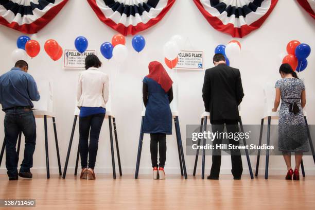 voters voting in polling place - voting booth stock pictures, royalty-free photos & images