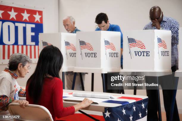 voters voting in polling place - voting booth stock pictures, royalty-free photos & images