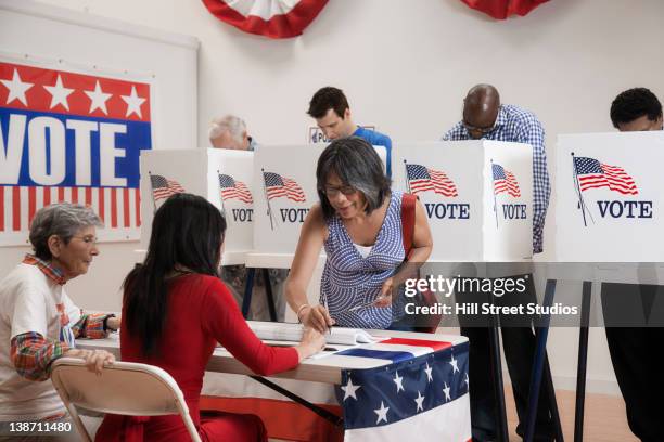voters voting in polling place - american election stock pictures, royalty-free photos & images