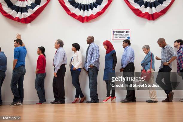 voters waiting to vote in polling place - voting line stock pictures, royalty-free photos & images