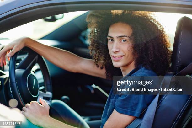 mixed race teenager sitting in car - boy with long hair stock pictures, royalty-free photos & images