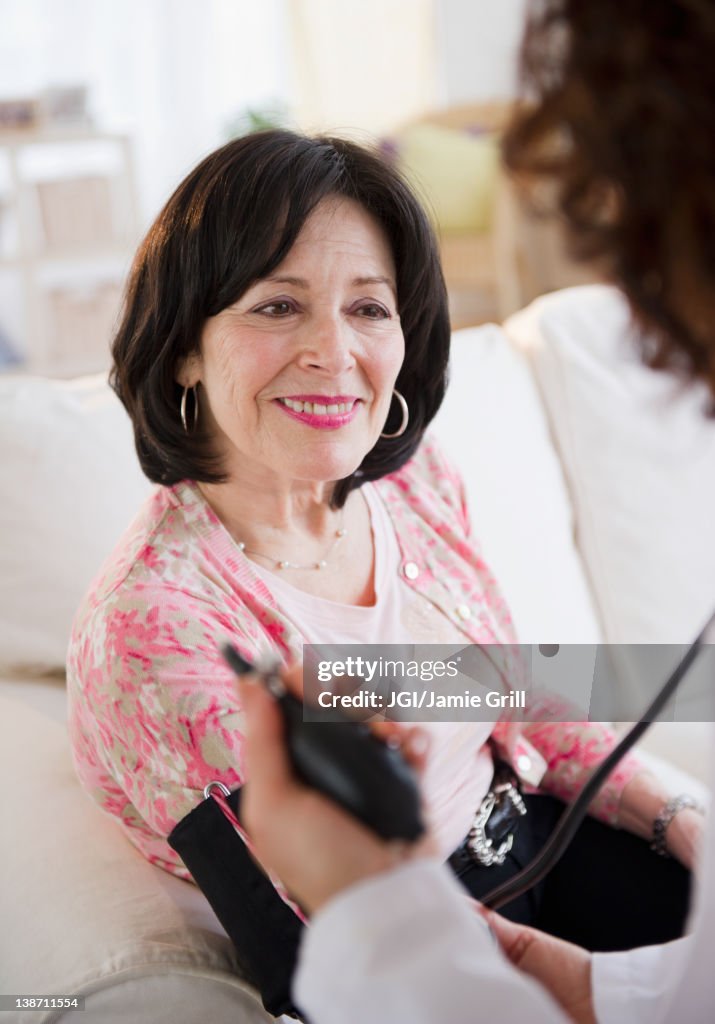 Doctor taking patient's blood pressure