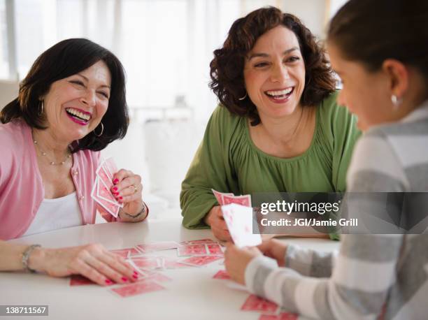 grandmother, mother and daughter playing cards - card game mature people stock-fotos und bilder