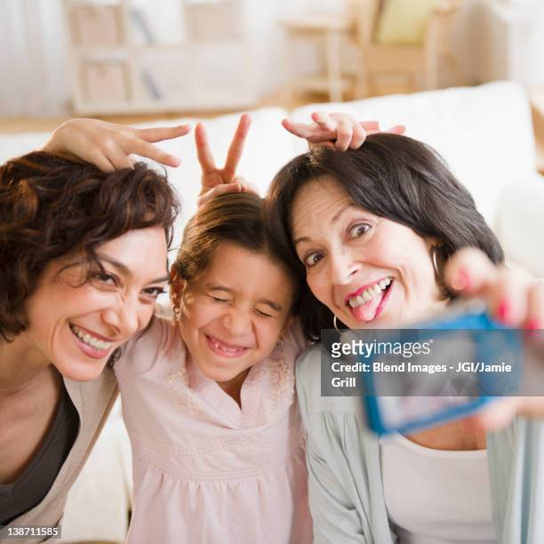 family taking self-portrait with digital camera - mamie grimace photos et images de collection