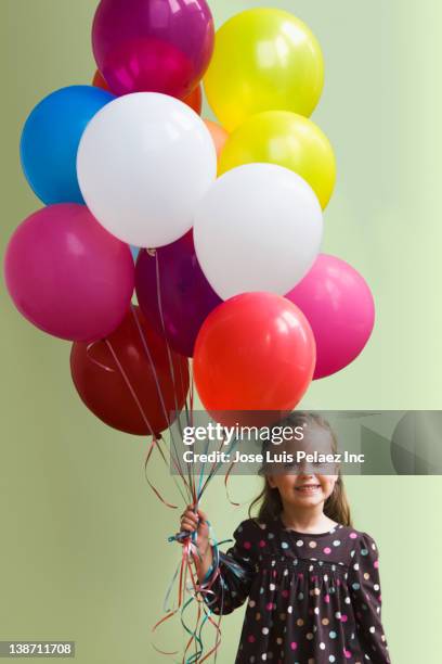 caucasian girl holding floating balloons - child balloon studio photos et images de collection
