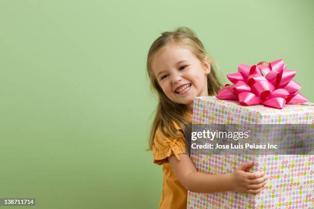 smiling caucasian girl holding birthday gift - kids birthday present stock pictures, royalty-free photos & images