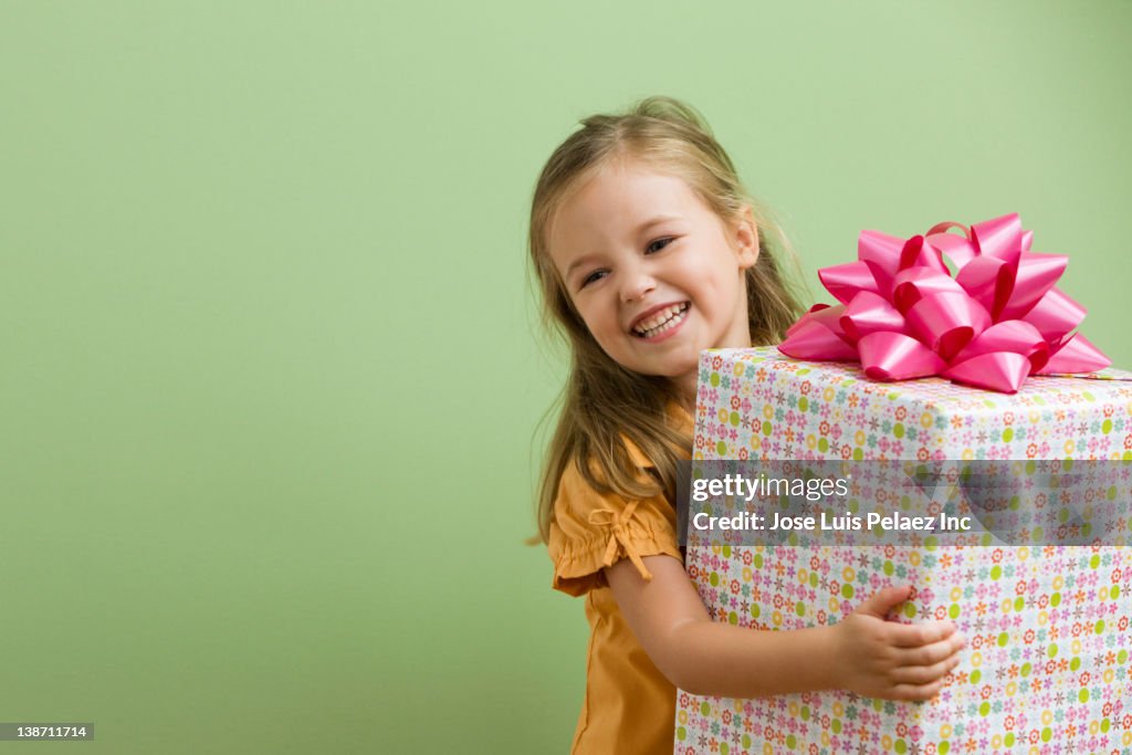 Smiling Caucasian girl holding birthday gift