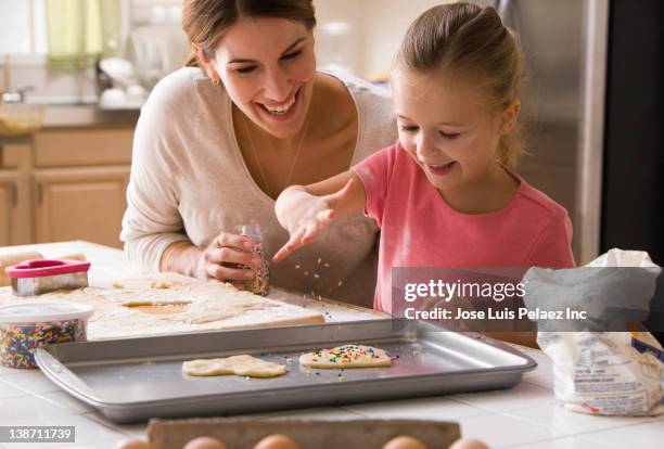 caucasian mother and daughter making valentine cookies - formine foto e immagini stock