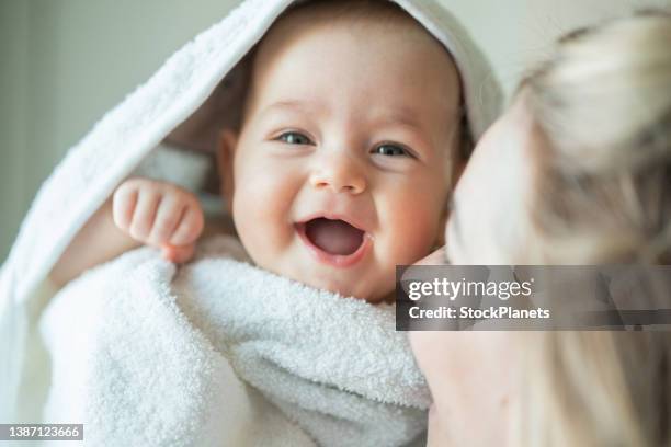 woman carrying her baby girl at home - baby in towel stock pictures, royalty-free photos & images