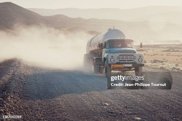 typical old-styled zil truck on a dirt road in rural uzbekistan - soviet truck near samarkand, central asia - old truck fotografías e imágenes de stock