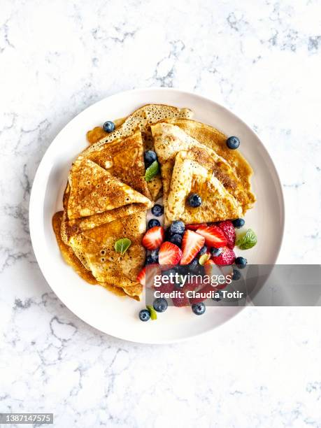 plate of crepes with berries on white background - maple syrup pancakes stockfoto's en -beelden