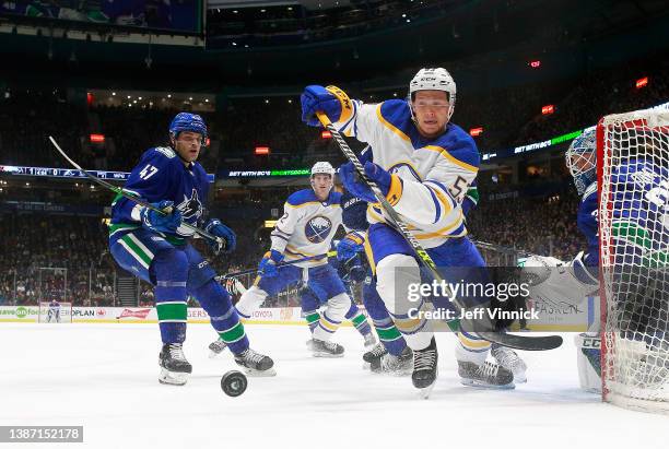 Jeff Skinner of the Buffalo Sabres and Noah Juulsen of the Vancouver Canucks watch a loose puck during their NHL game at Rogers Arena March 20, 2022...