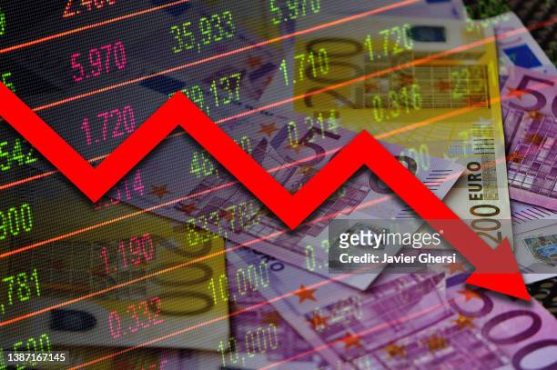 economy graph: red down arrow, cash euro banknotes and stock exchange board - hinunter bewegen stock-fotos und bilder