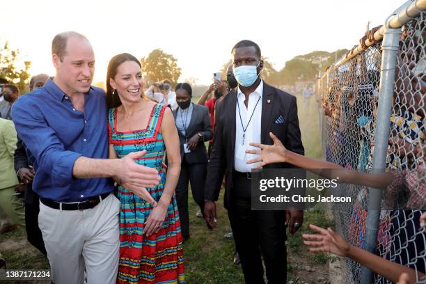 Prince William, Duke of Cambridge and Catherine, Duchess of Cambridge shake hands with children during a visit to Trench Town, the birthplace of...