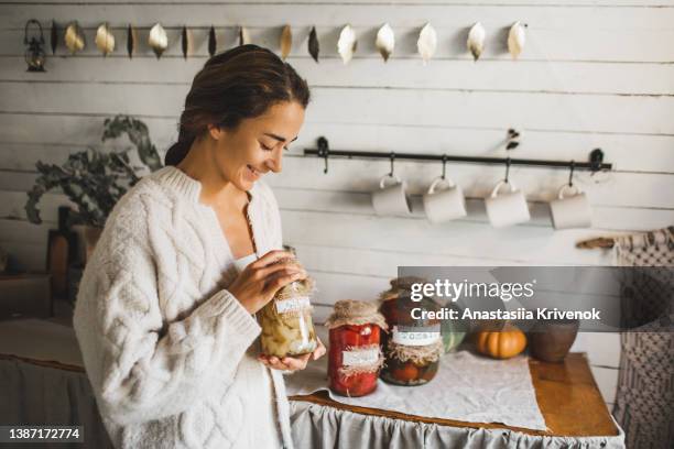 young woman cans and pickles vegetables. - eingelegt stock-fotos und bilder