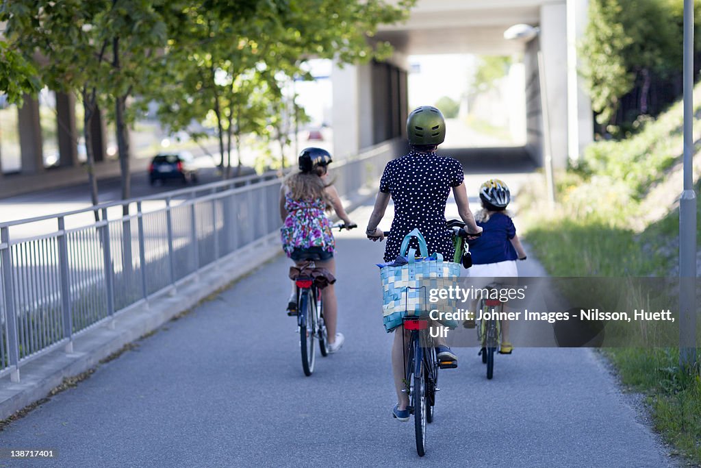 A woman and two children riding bikes