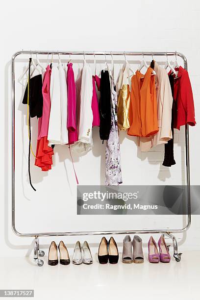 clothing rail with pairs of footwear on white bakcground - colorful shoes ストックフォトと画像