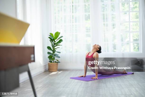 young sporty woman practicing yoga, doing upward facing dog exercise - salutation au soleil photos et images de collection