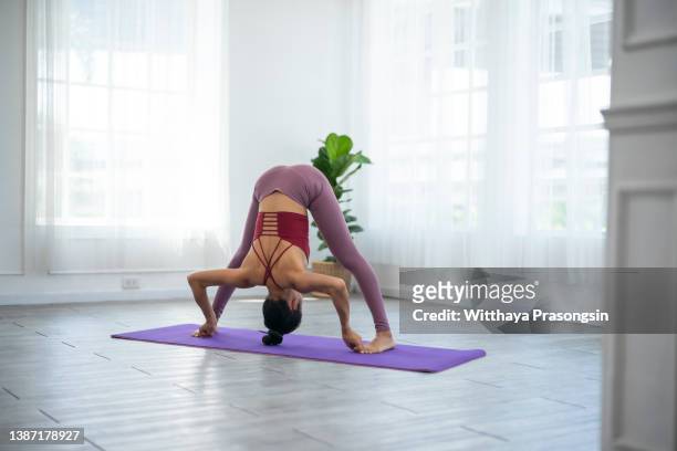 young woman practicing yoga - yin yoga stock-fotos und bilder