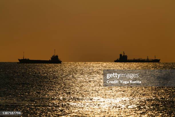freighter sailing on a sea at sunset - generic location stock pictures, royalty-free photos & images