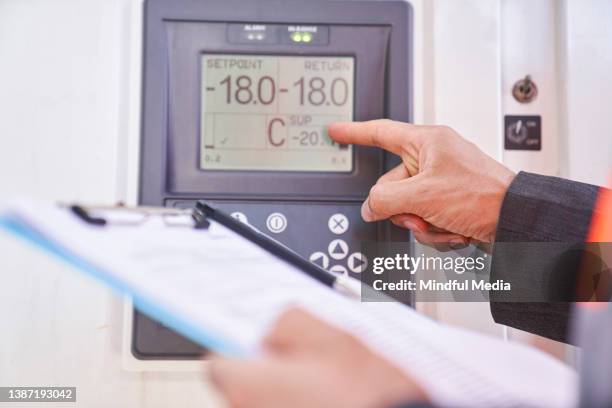 gros plan d’un superviseur américain d’origine asiatique vérifiant la température sur le panneau du conteneur frigorifique - température photos et images de collection