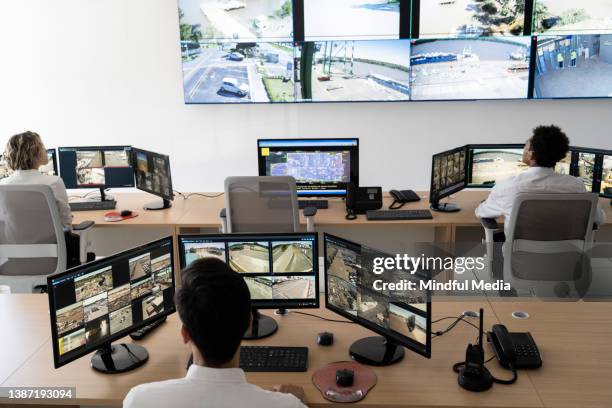security guards working at control room while looking at video wall - kontrollrum bildbanksfoton och bilder