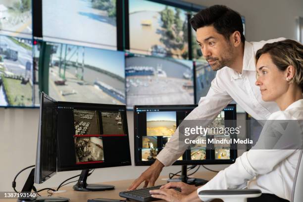 male and female security coworkers watching monitors at control room - guarding stock pictures, royalty-free photos & images