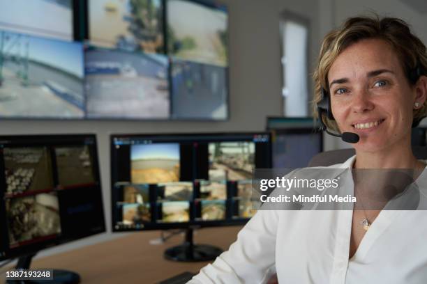 adult female security worker wearing wireless headset at control room - security guard stock pictures, royalty-free photos & images