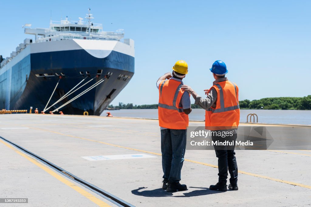 Dockkontrollmitarbeiter diskutieren beim Betrachten des Schiffes