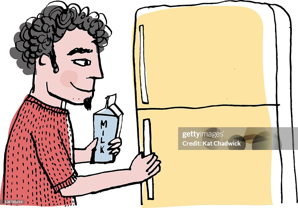 A man opening a fridge to put milk in it